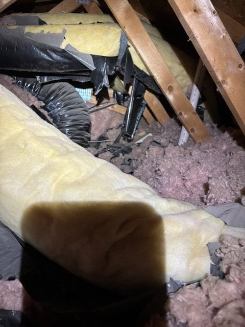 Damaged ductwork and insulation before repair