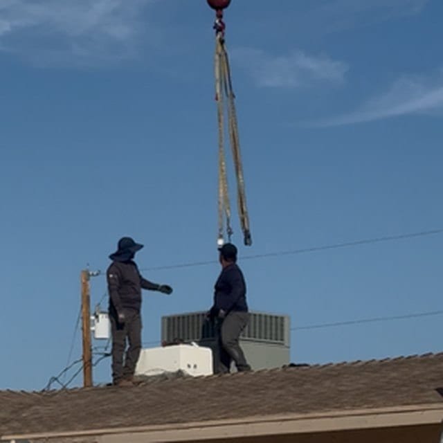 Crane rigging above a rooftop package-unit replacement