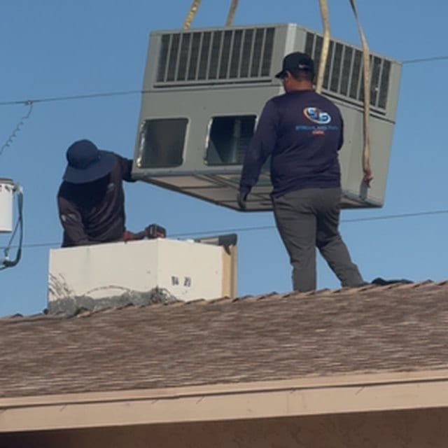 Technician guiding the package unit as it is set on the roof